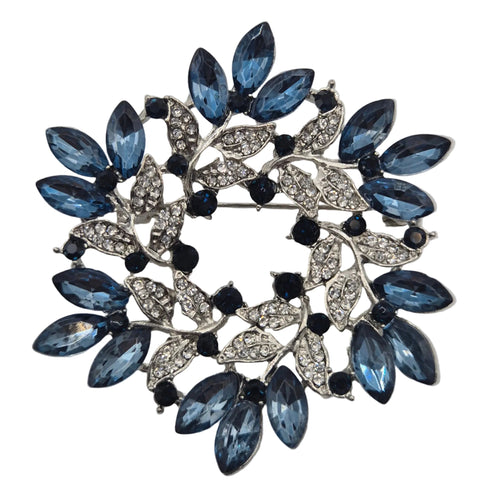 Blue and silver wreath brooch on white background close up