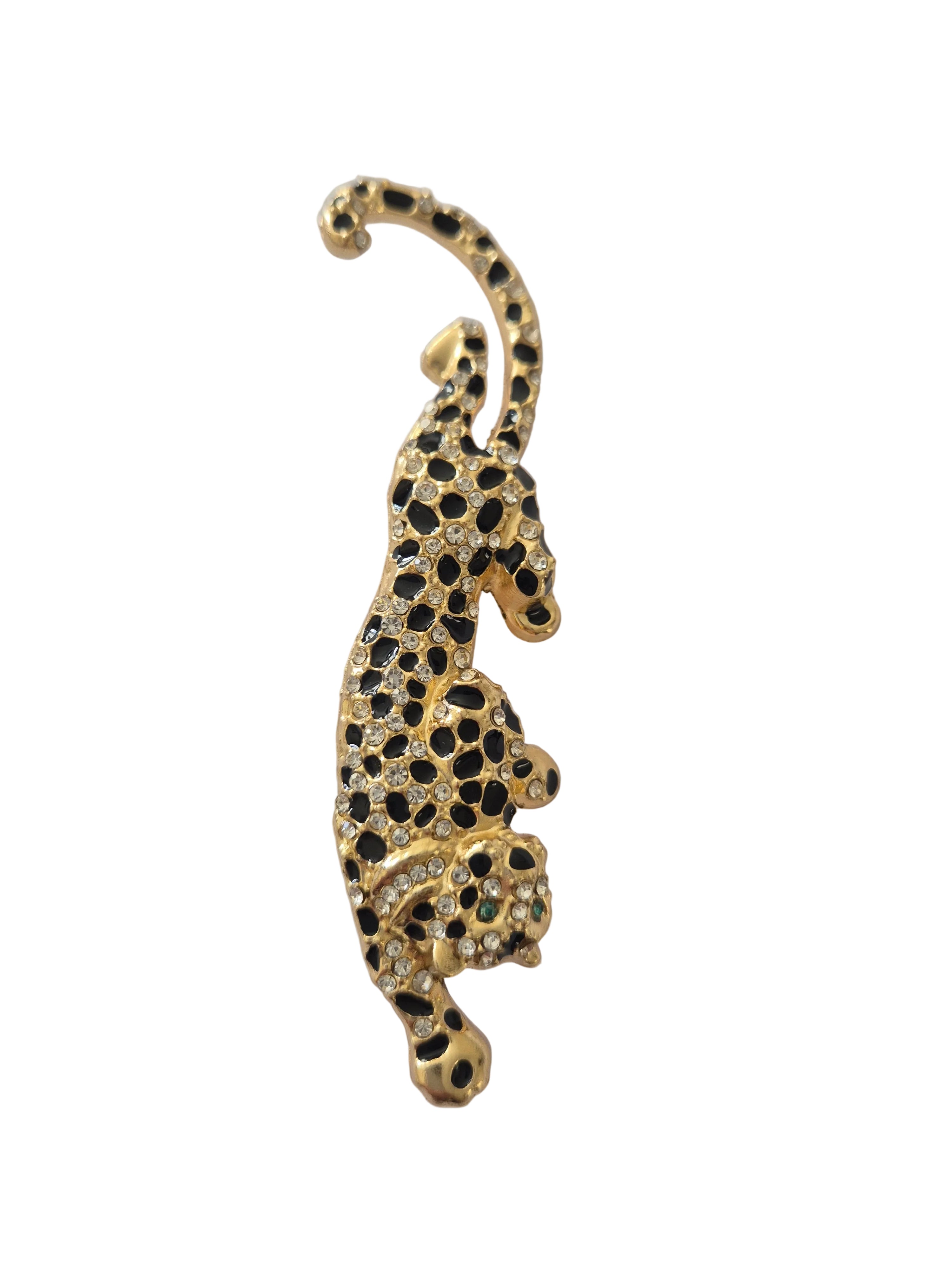 Gold and black jeweled leopard brooch on a white background