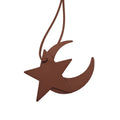 A brown faux-leather bag charm shaped like a star overlapping a crescent moon, suspended by a matching cord on a plain white background.