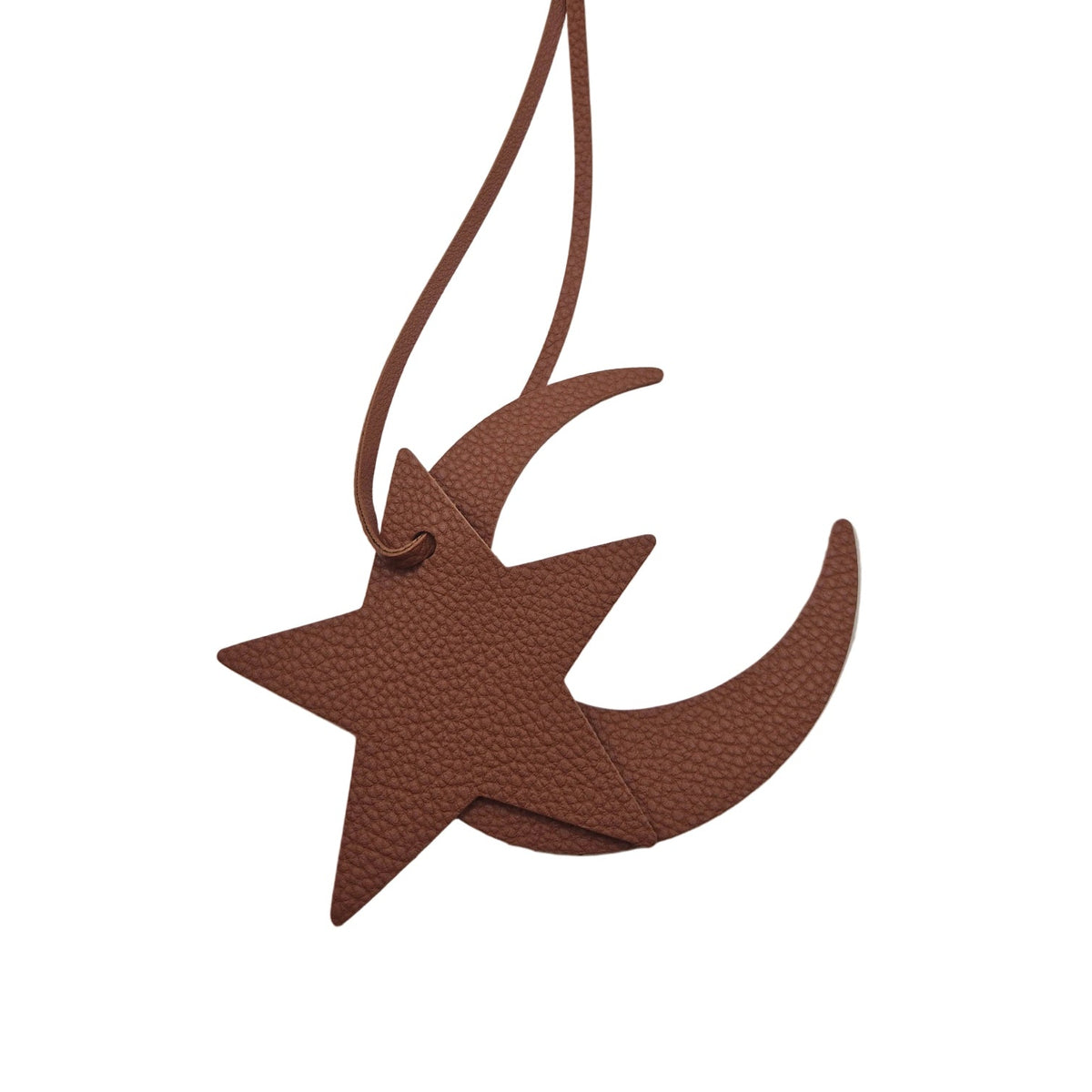 A brown faux-leather bag charm shaped like a star overlapping a crescent moon, suspended by a matching cord on a plain white background.