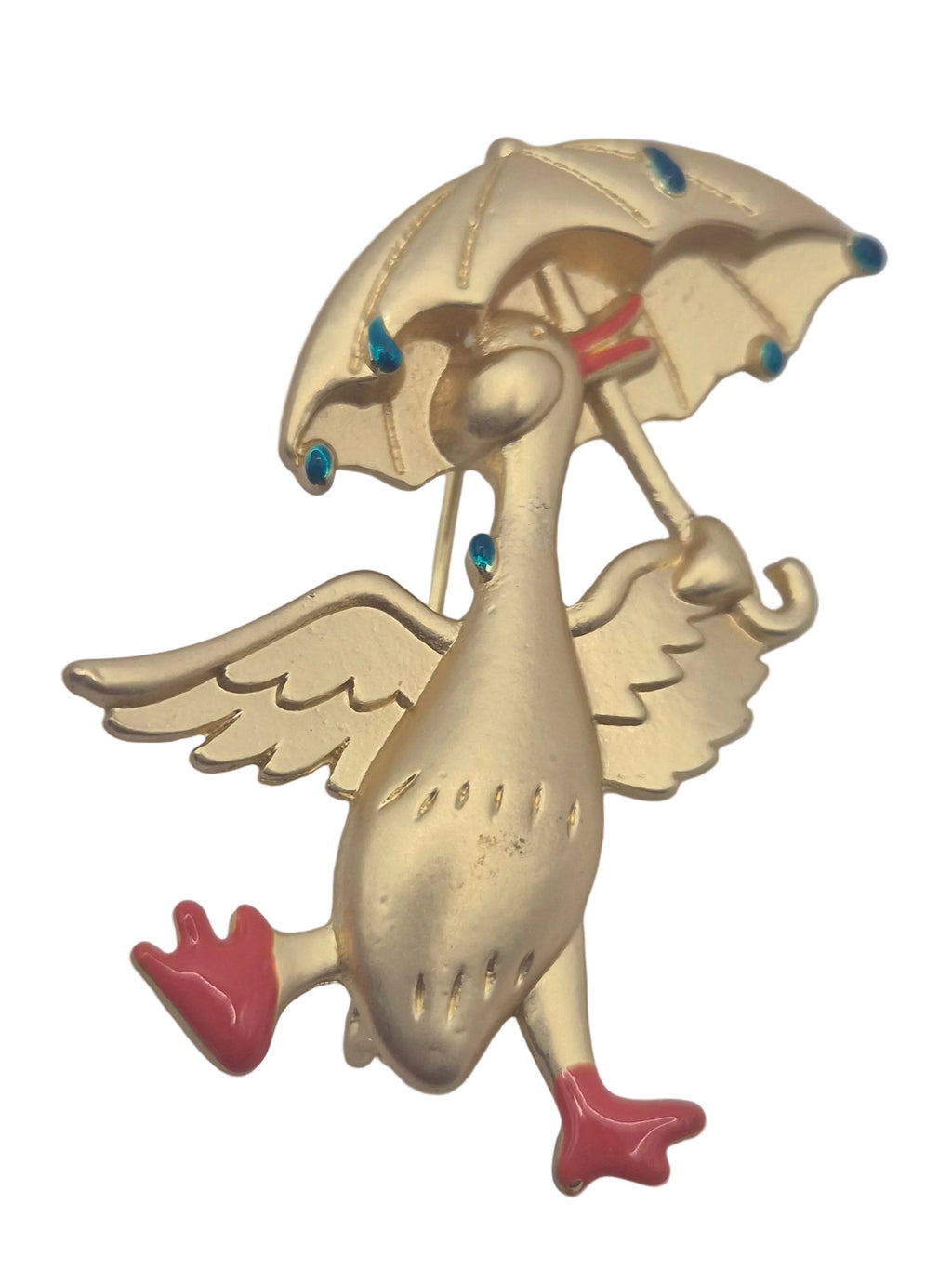 Gold tone metal duck holding an umbrella brooch with raindrops on a plain white background 