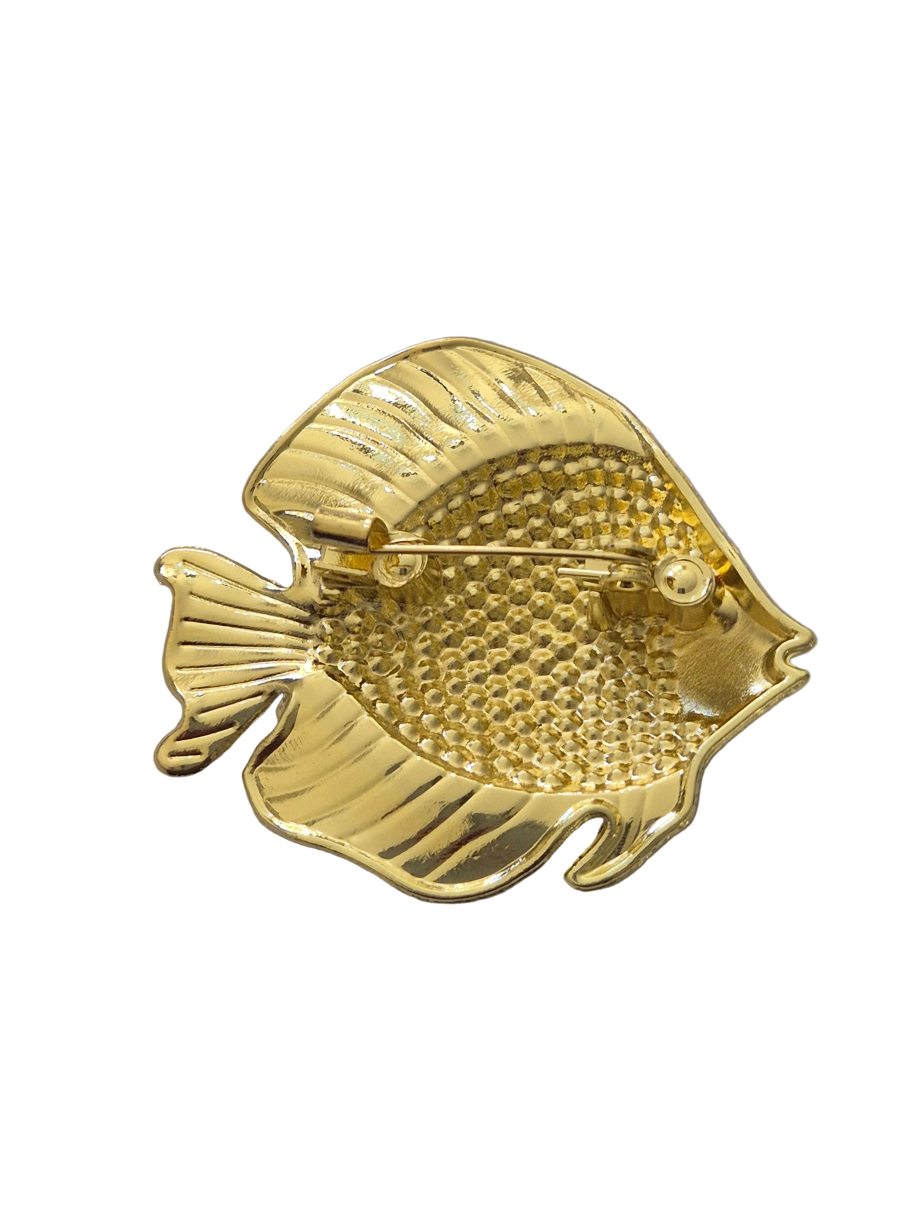 Gold fish-shaped brooch on a white background