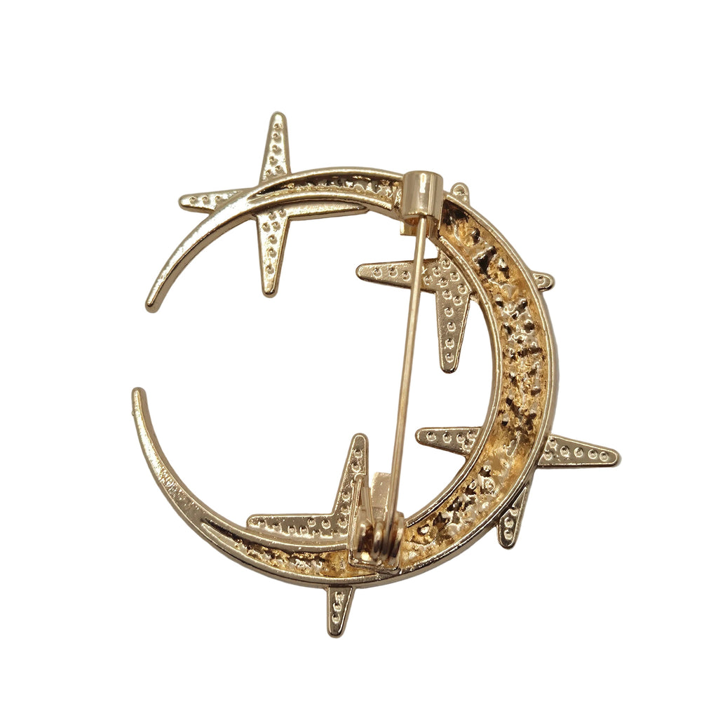 Gold rhinestone moon and stars celestial brooch detail on white background