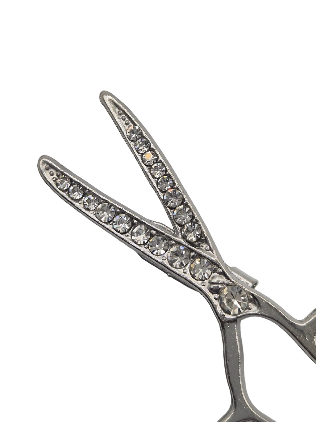 Silver scissors-shaped brooch with crystal embellishments on a white background