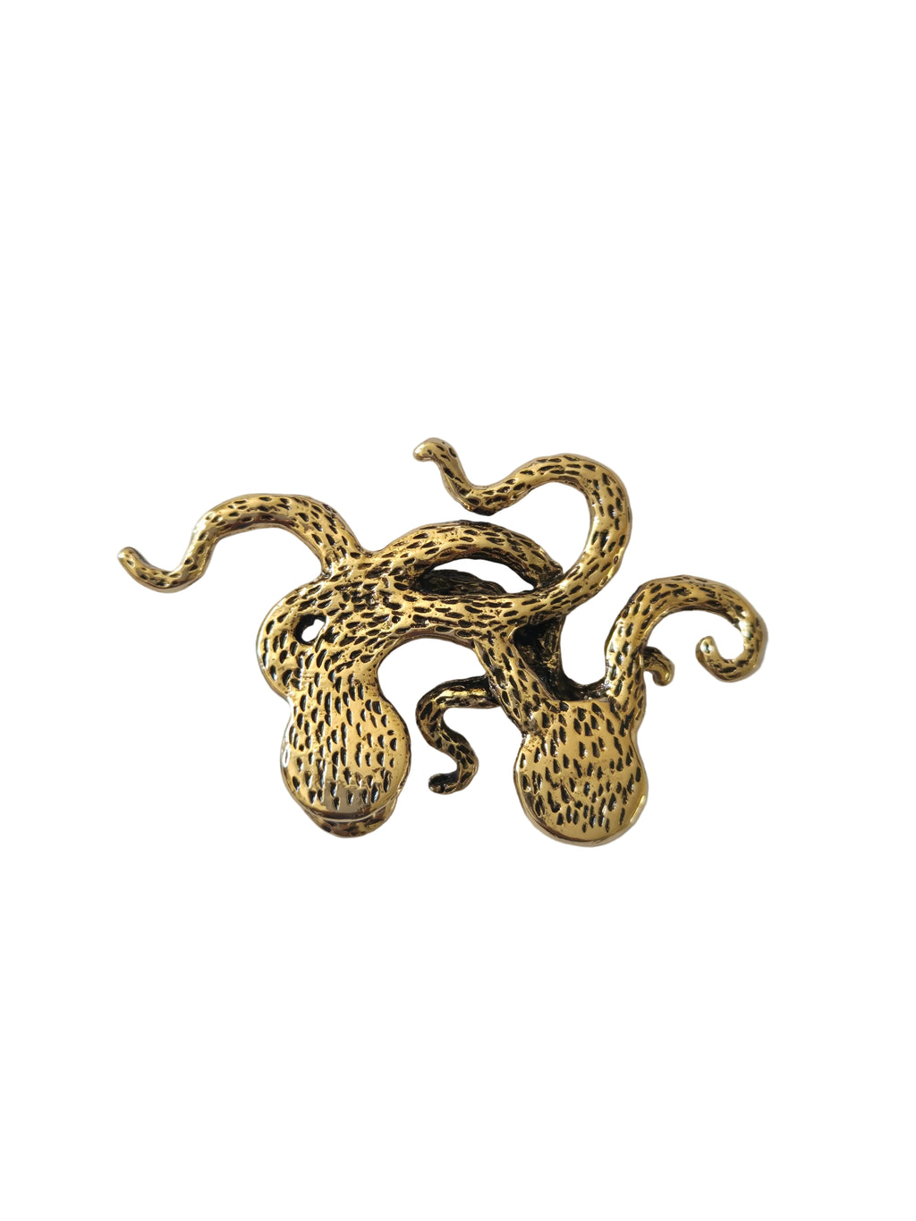 Gold octopus shaped brooch on a light gray background
