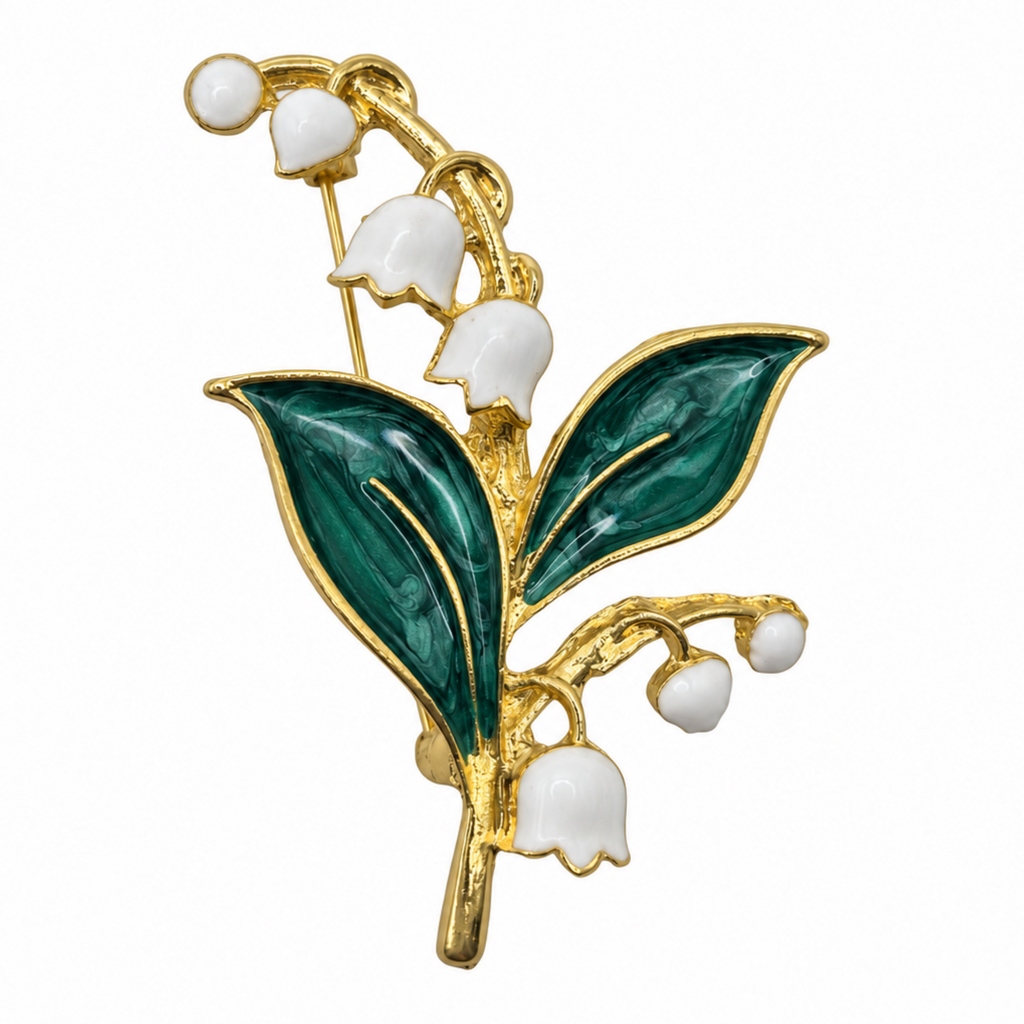 A lily of the valley flower brooch featuring white enamel blossoms and dark green enamel leaves, set in gold-tone metal, shown against a plain white background.