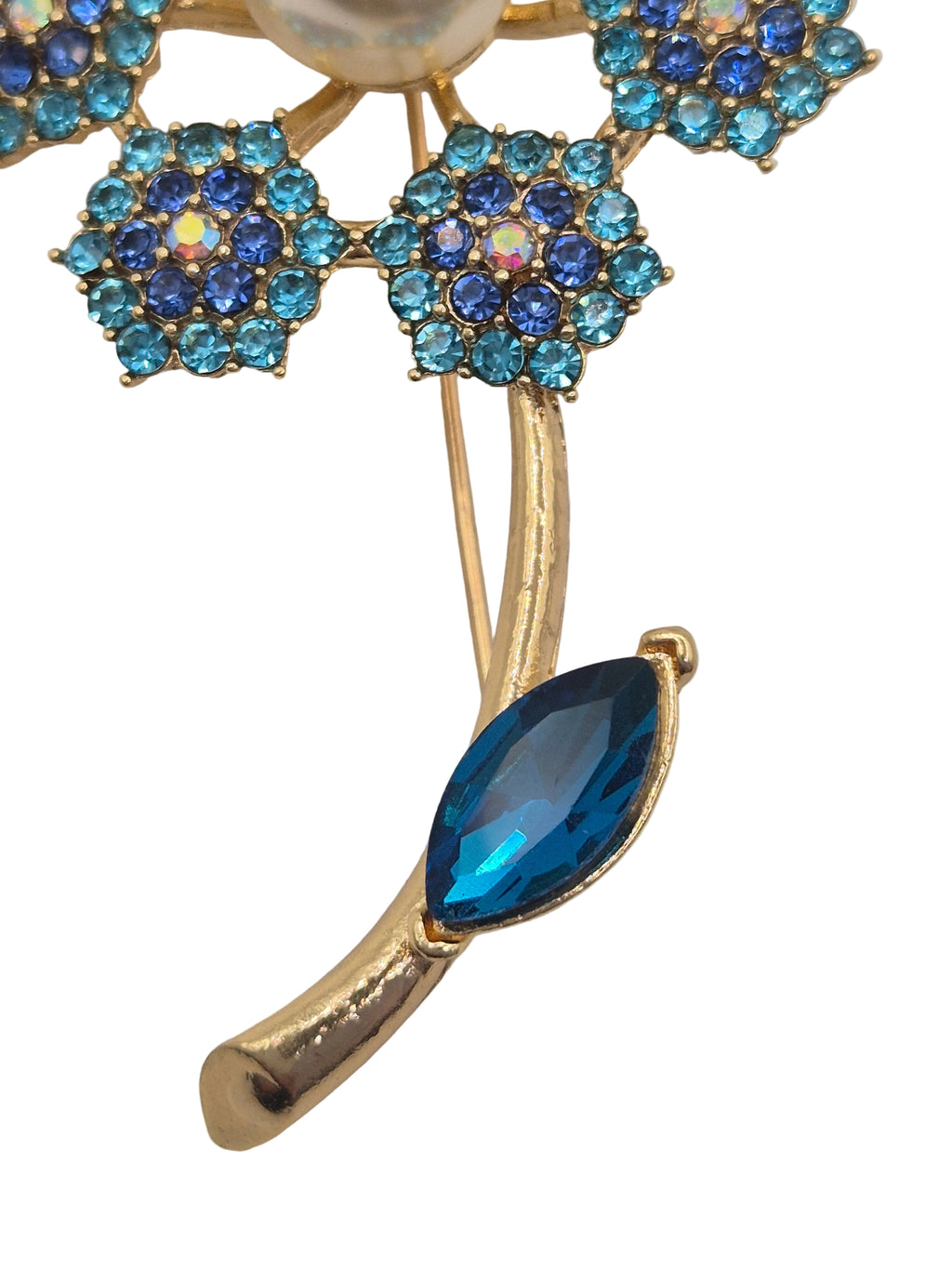 Gold brooch with blue gemstones on a white background