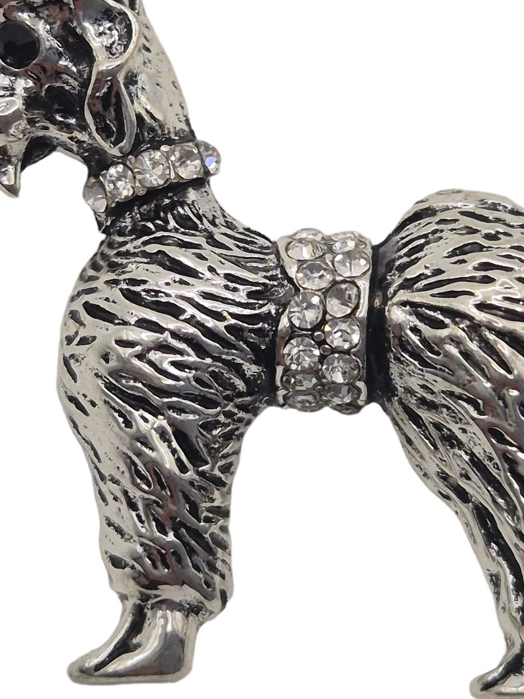 A silver-toned metal dog figurine or charm with a textured fur pattern and clear rhinestone embellishments on the collar and girth, shown against a plain white background.