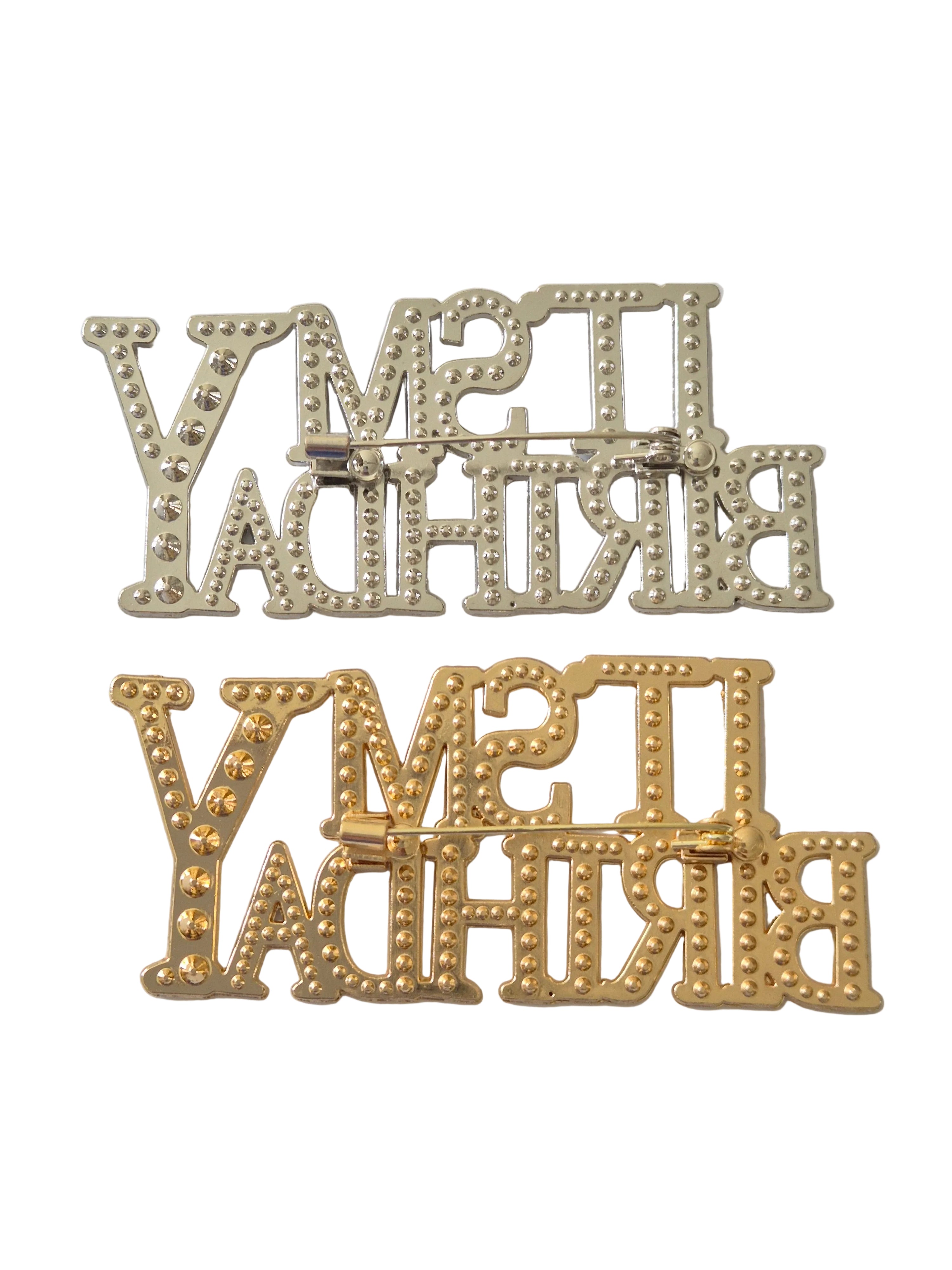 Gold and silver decorative metal brooches on a light gray background