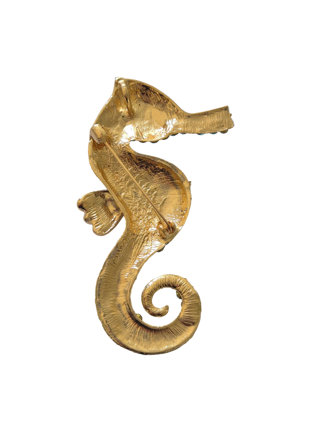 Gold seahorse decorative brooch on a white background