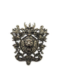silver metal brooch with a lion's head design on a white background