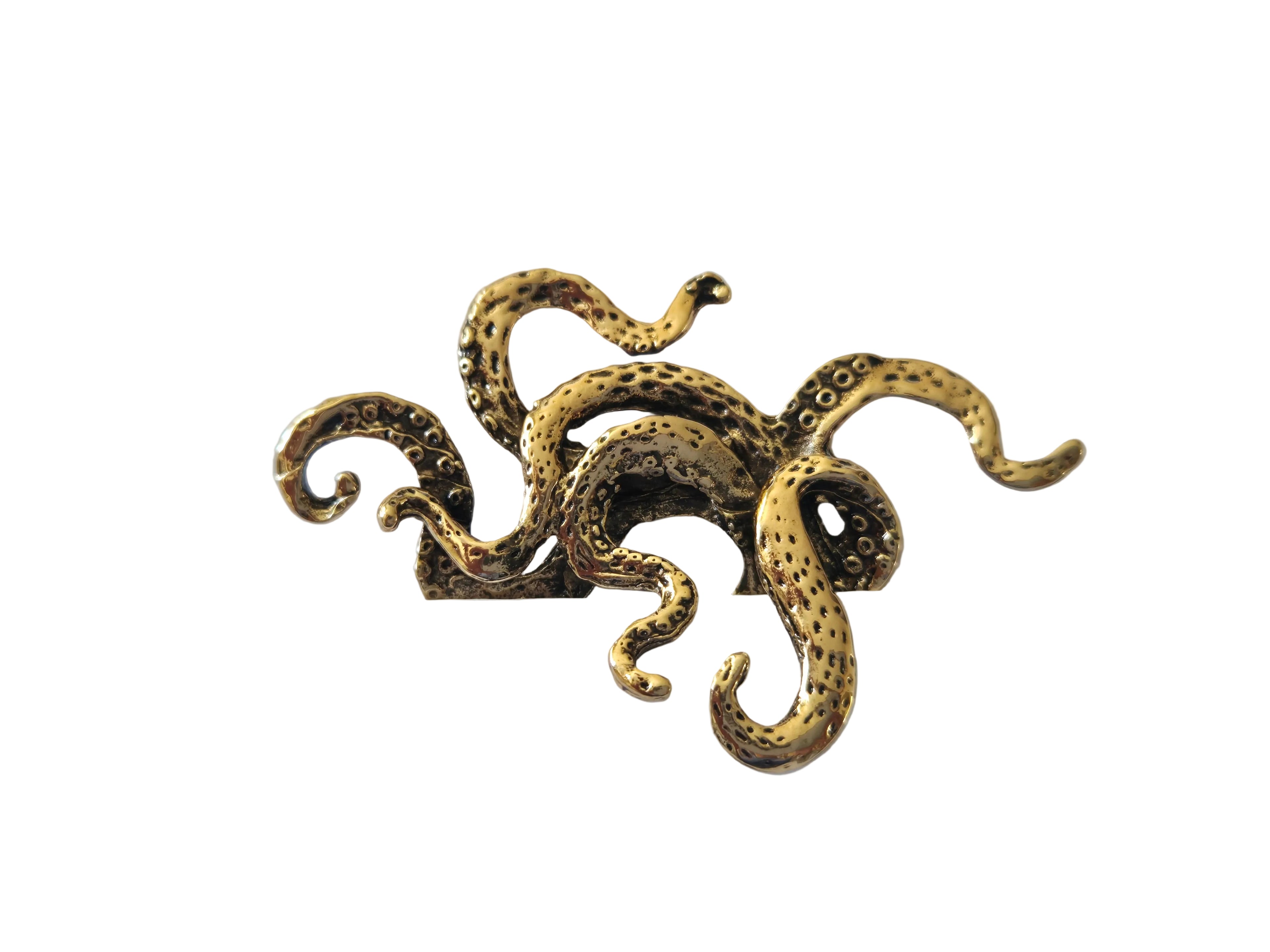 Gold octopus-shaped brooch on a white surface