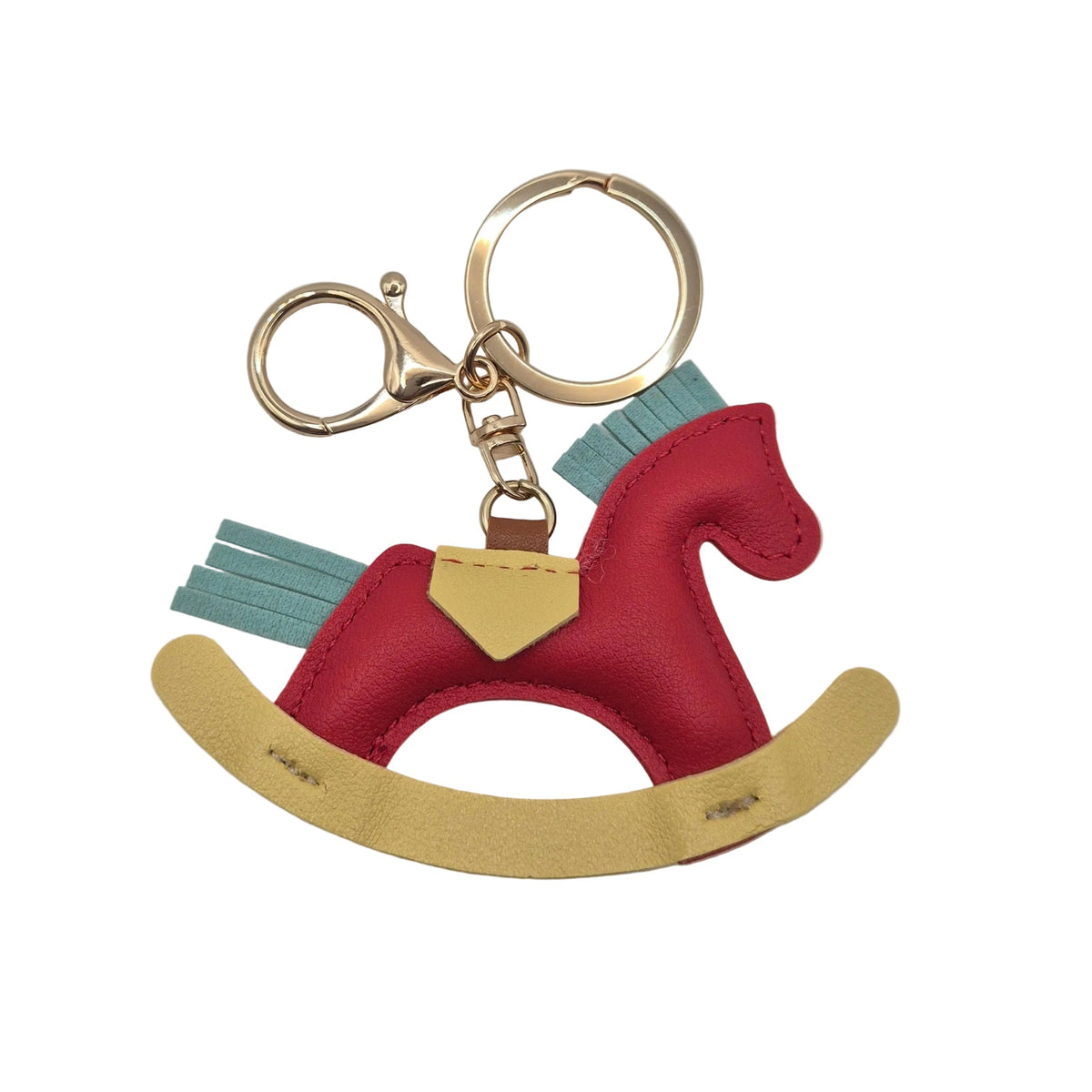 A small rocking horse keychain charm made from red, light blue, and yellow faux leather, attached to gold-tone metal rings and a lobster clasp, photographed on a plain white background.