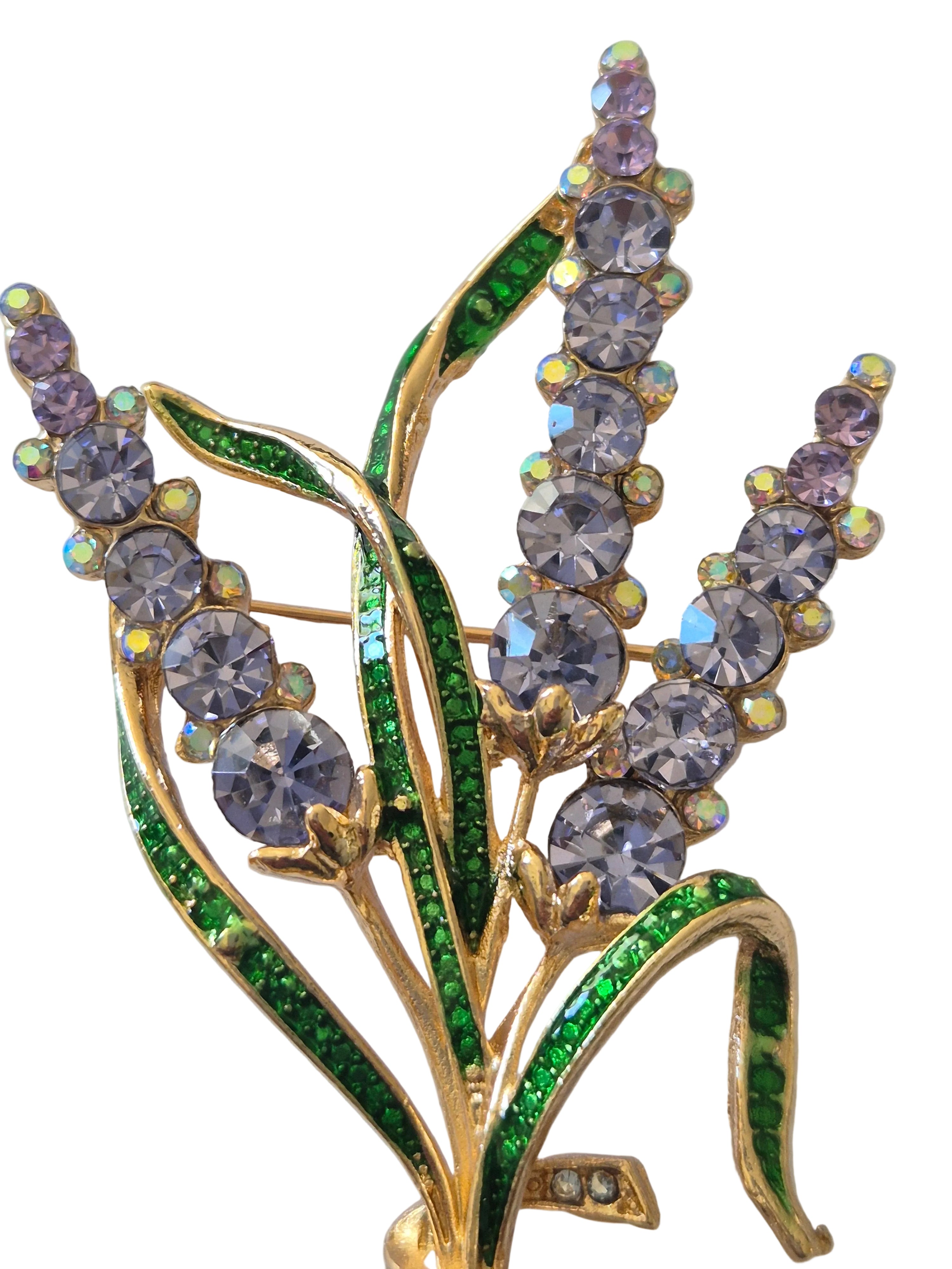 Decorative brooch with floral design and multicolored gemstones on a white background