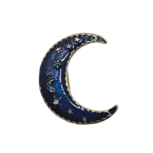 A crescent moon-shaped enamel pin in deep blue with gold-toned metal trim and small gold stars, photographed on a plain light gray background.