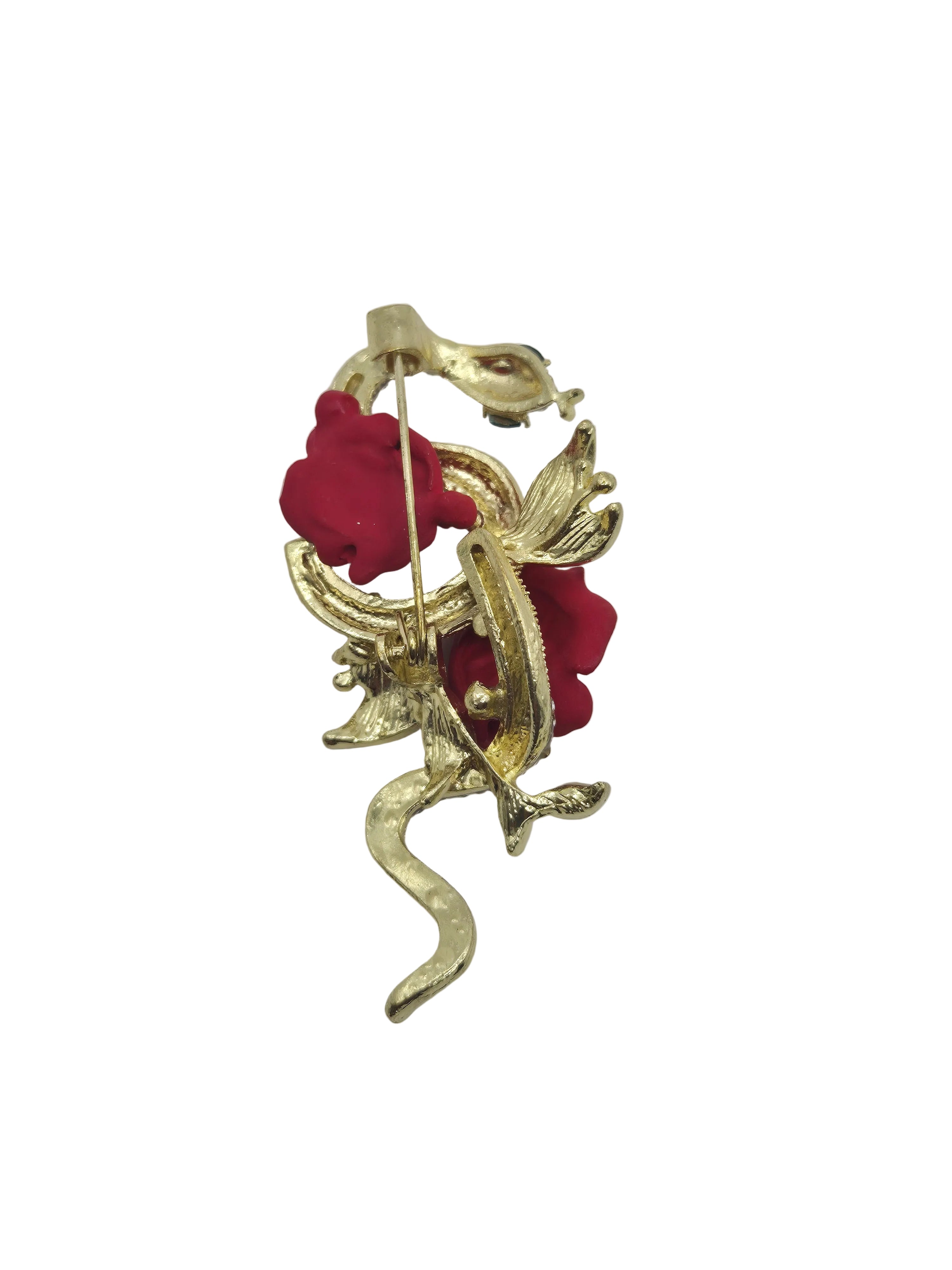 A vintage-style gold-tone brooch featuring sculpted gold leaves and red fabric roses, photographed on a plain white background.