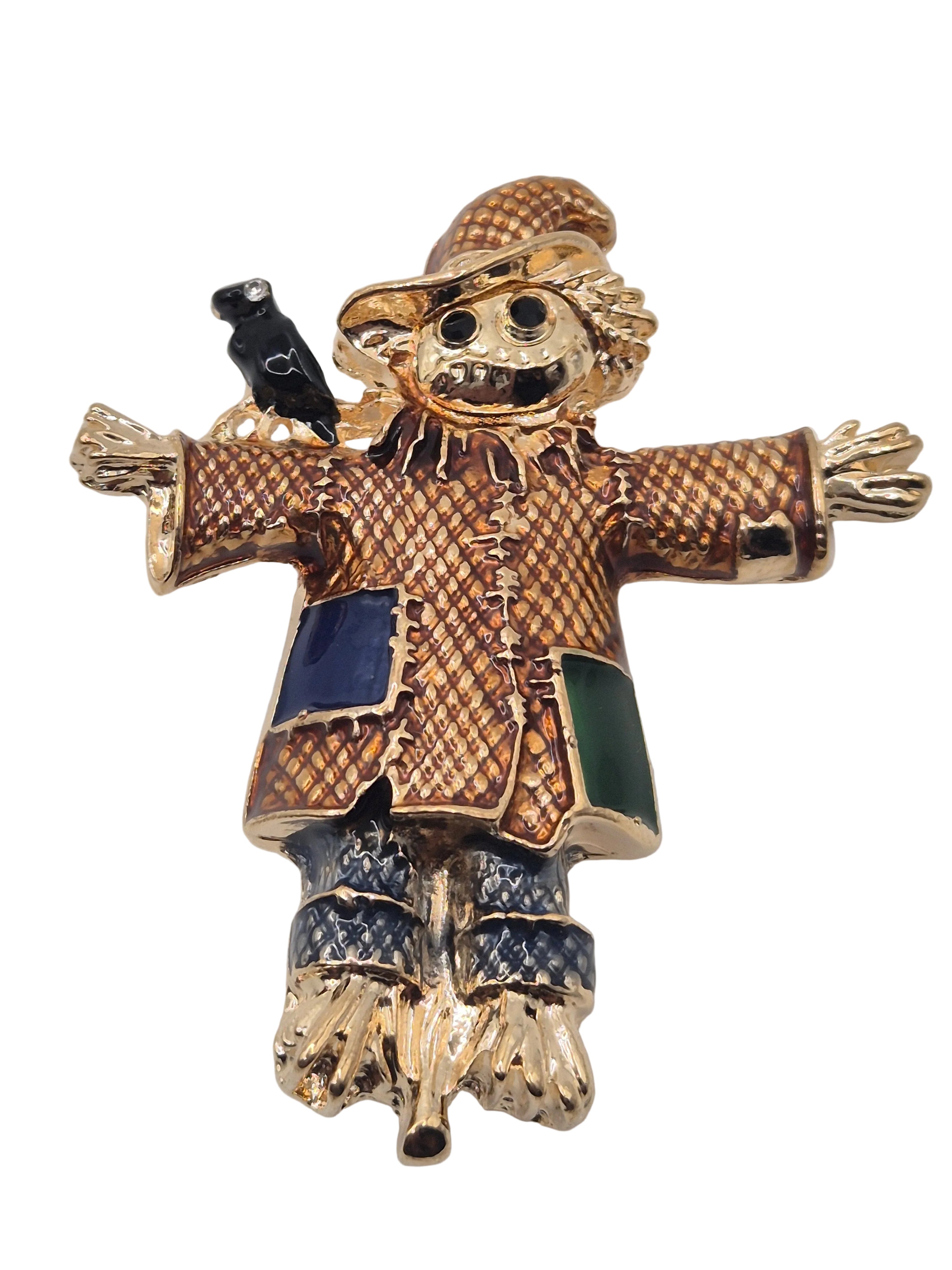 Gold scarecrow brooch with a white background