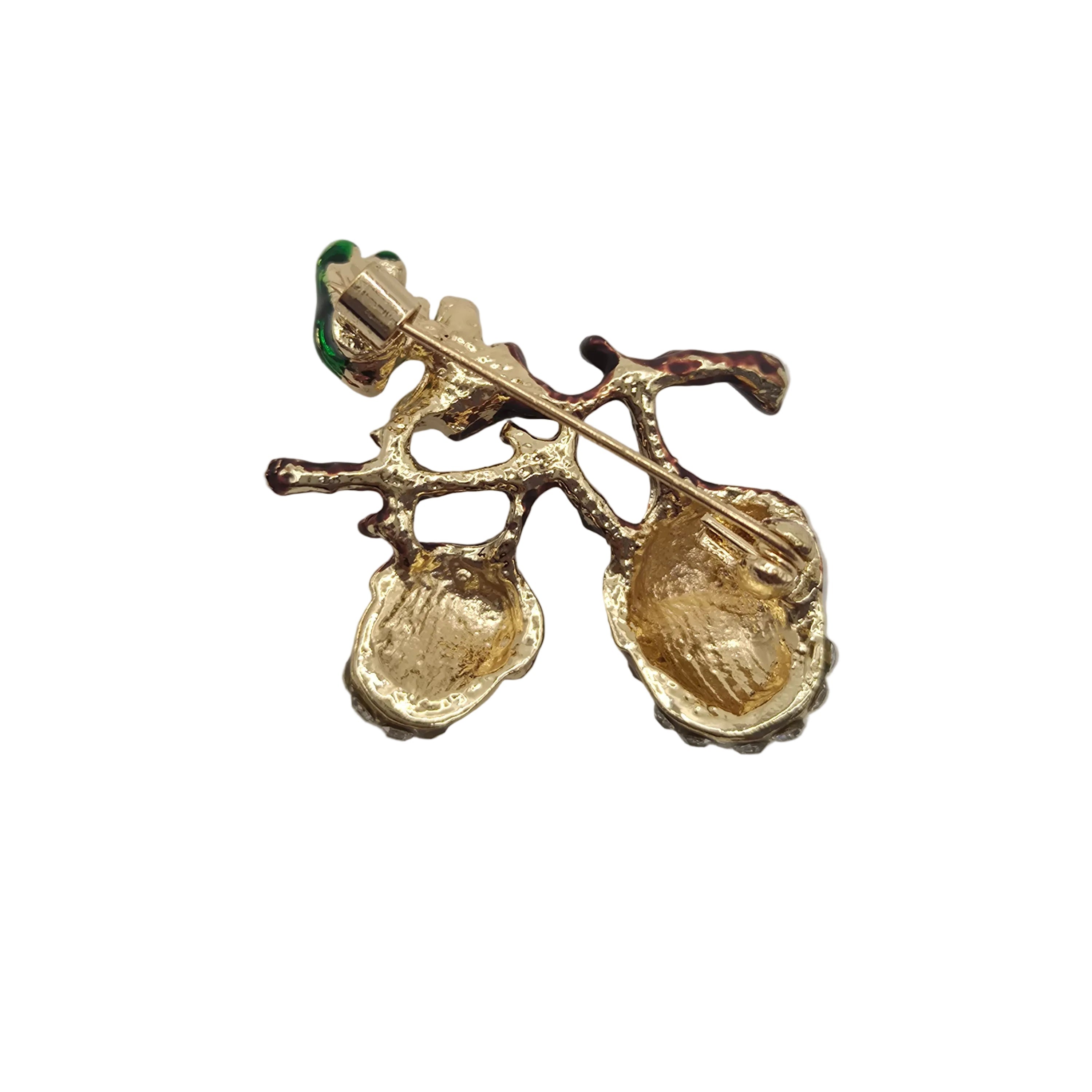 Reverse gold side of acorn brooch pin shown on a plain white background.