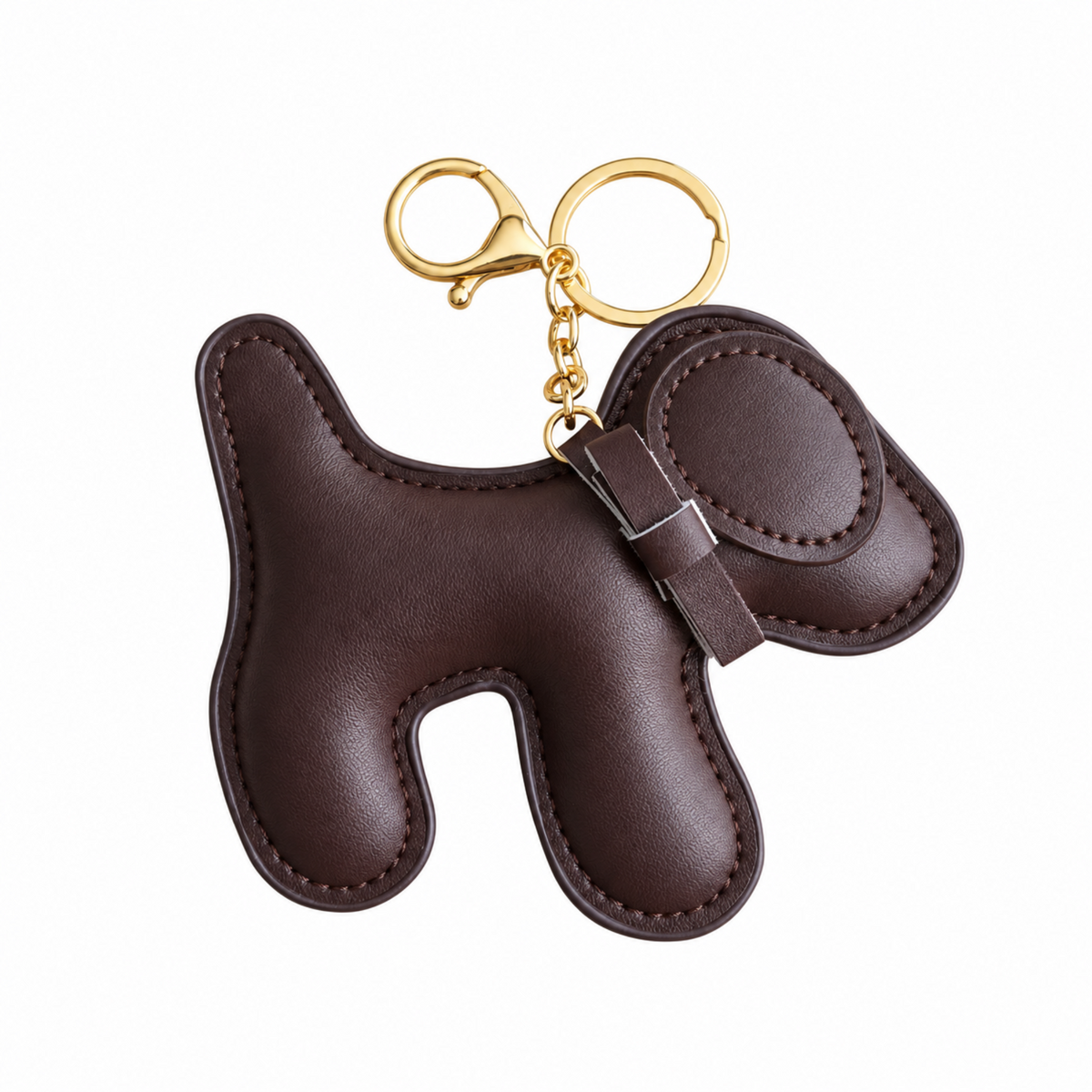 A dark brown leather dog-shaped keychain  bag charm with gold-tone metal hardware, shown on a plain white background.