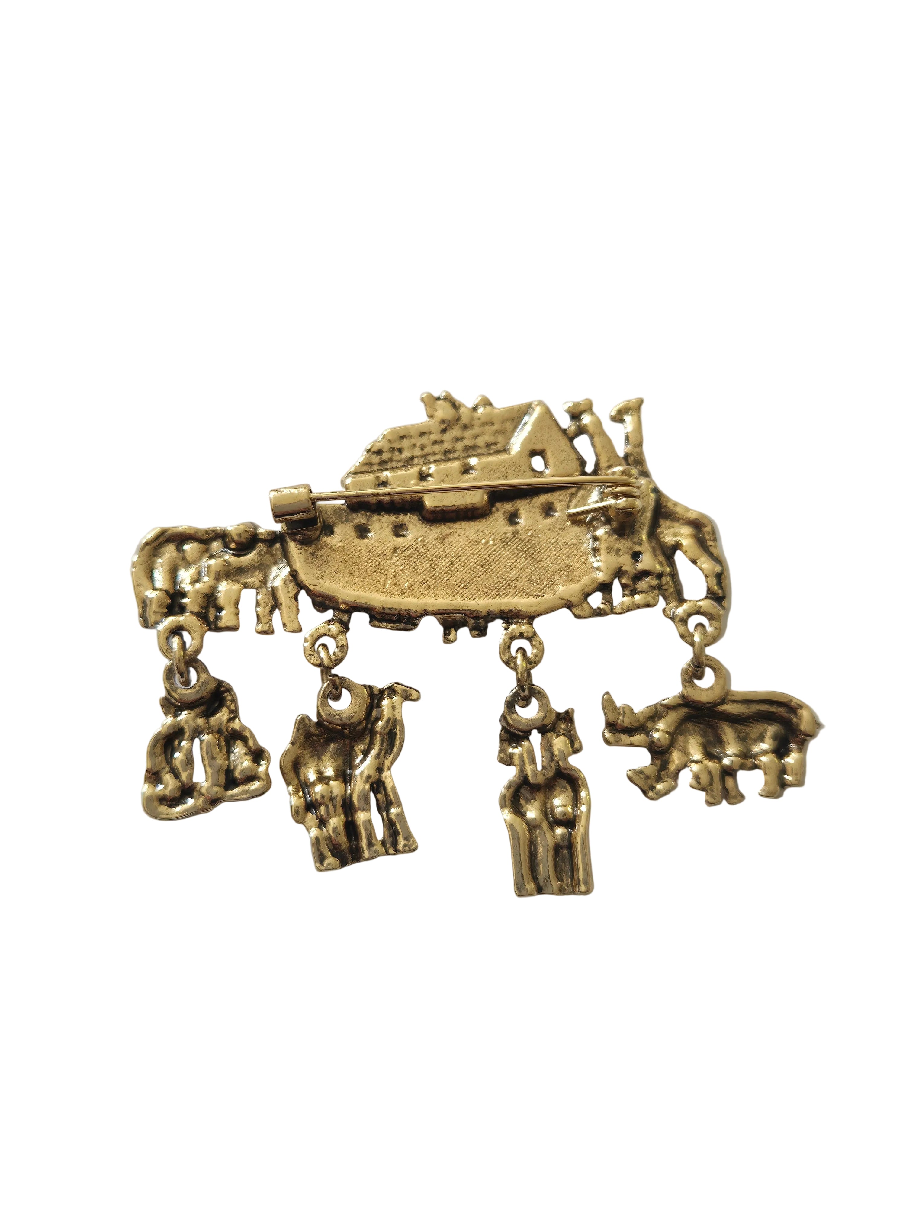 Gold-colored brooch with intricate design on a light gray background