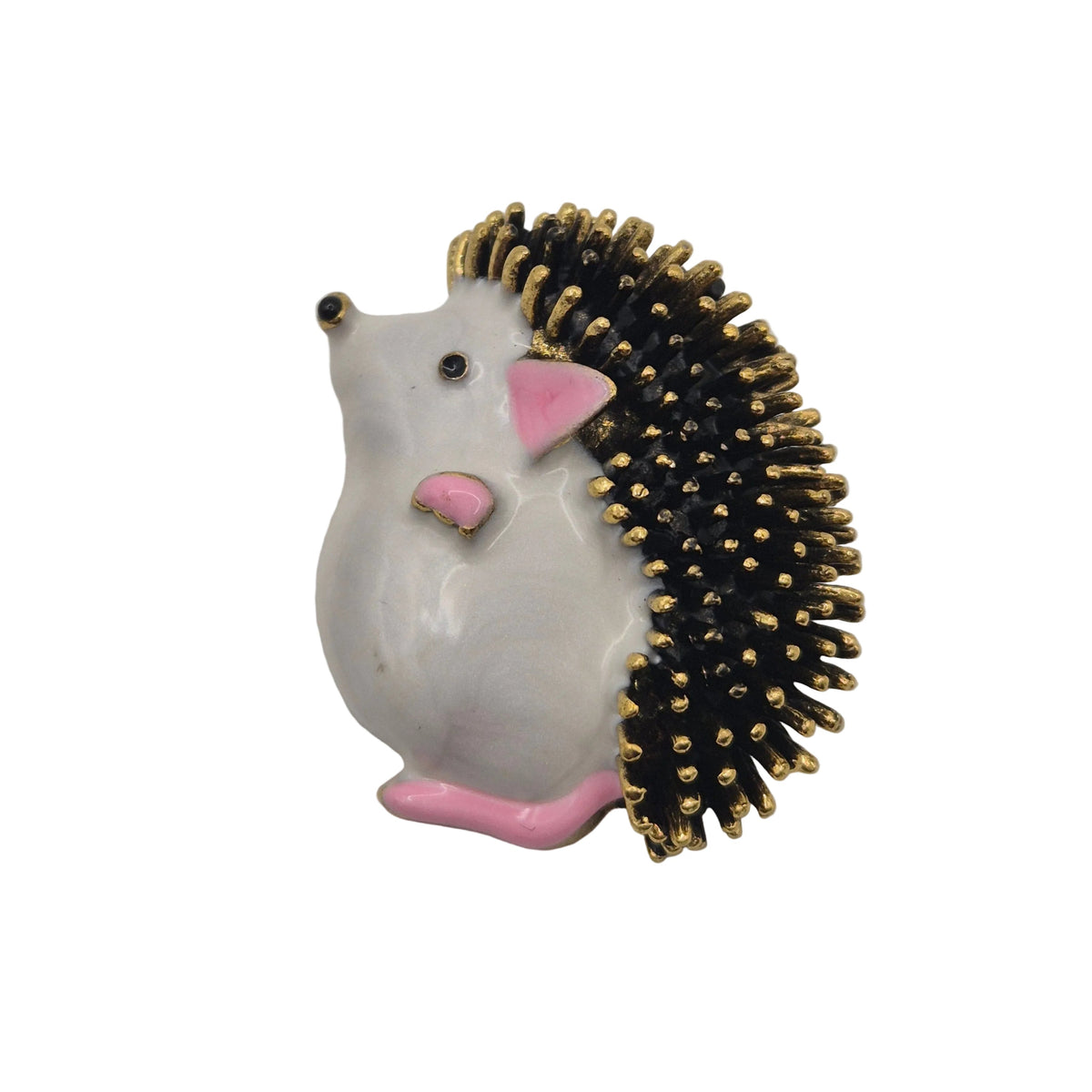 A small hedgehog-shaped brooch pin with a glossy white body, pink ears and feet, and black spines tipped with gold, photographed on a plain white background.