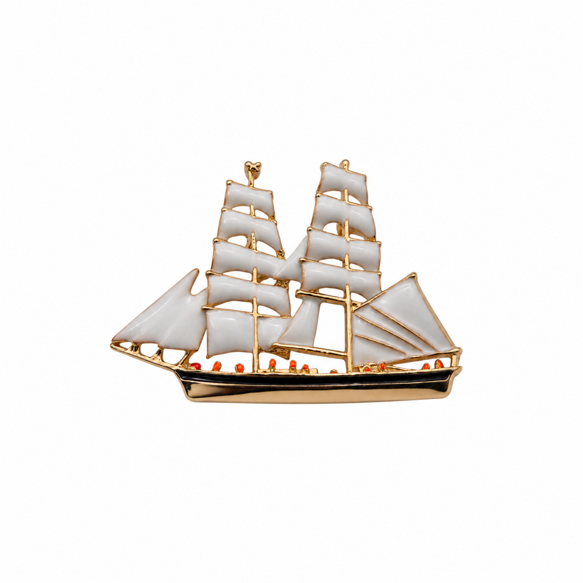 A gold-plated metal ship brooch with white enamel sails and small red accents along the hull, shown on a plain white background.