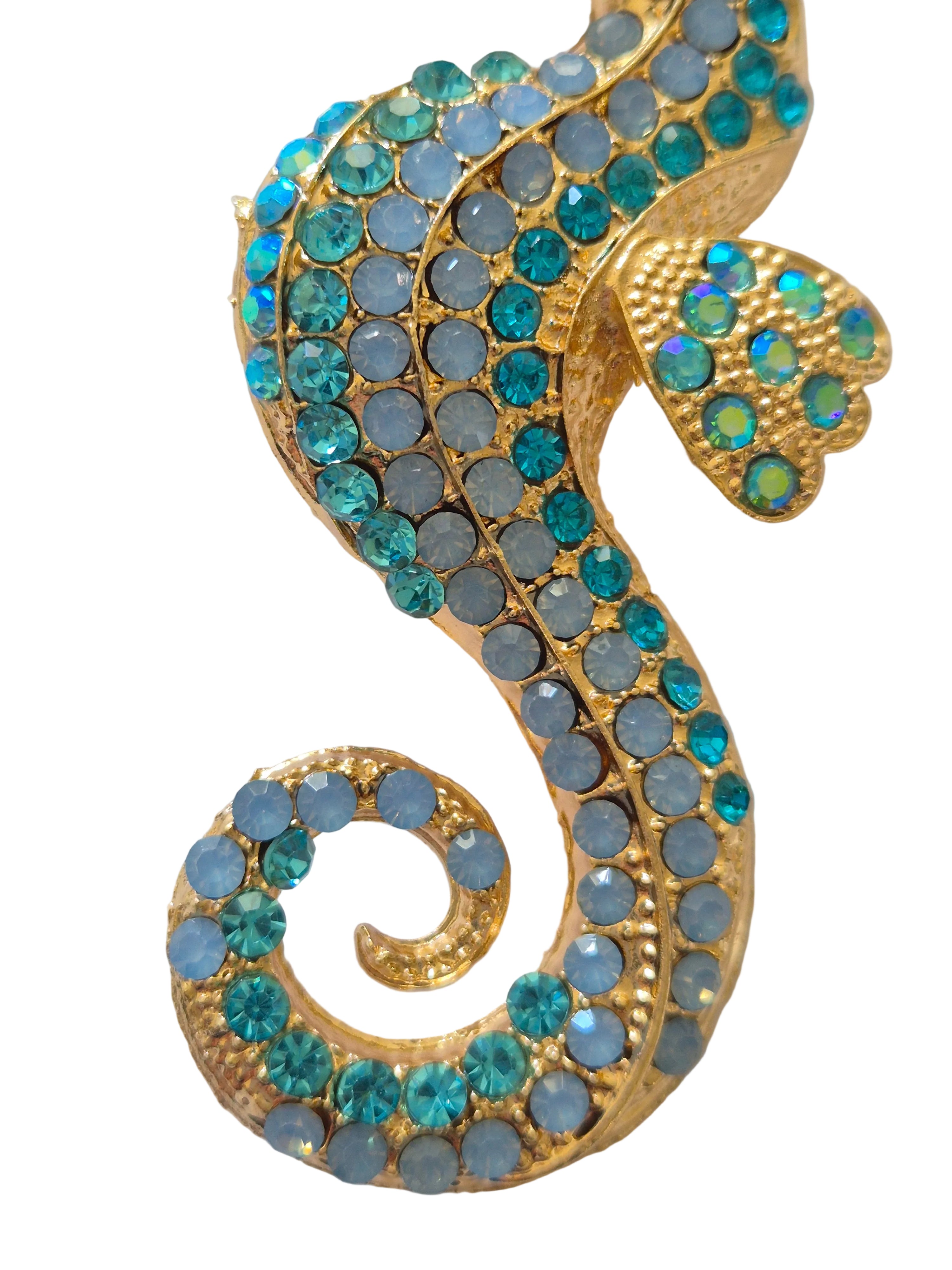 seahorse brooch with blue and gray stones on a white background