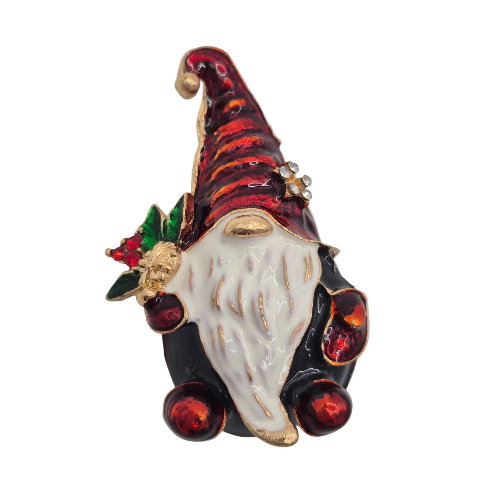 A festive gnome-shaped brooch with a red striped hat, white beard, black body, and small green and red holly accent, photographed on a plain white background.
