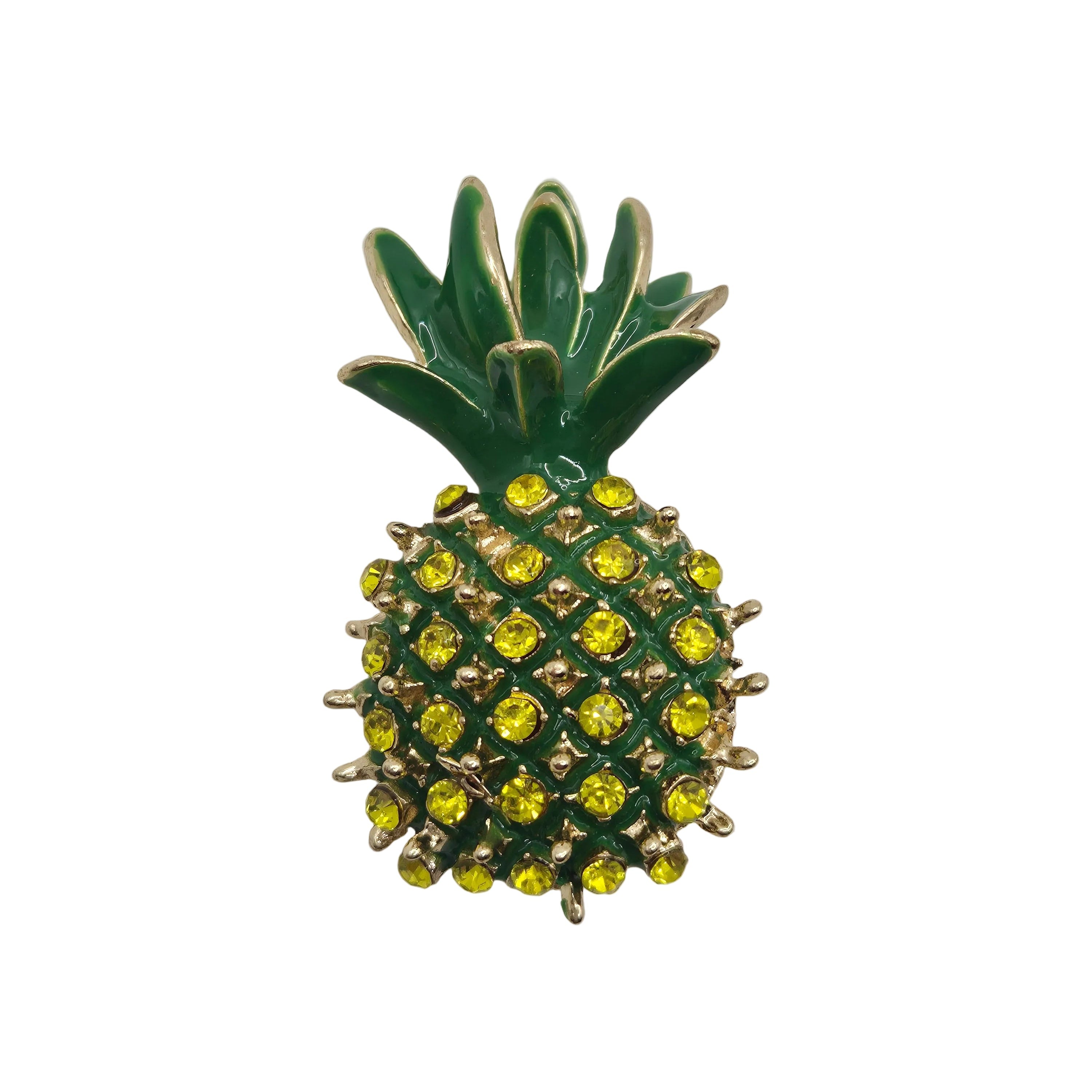 Pineapple-shaped brooch with green leaves and yellow gemstones on white background