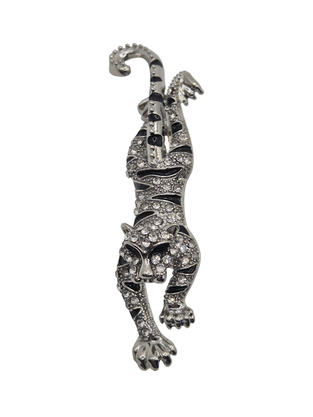 Silver tiger brooch with gemstones on a white background