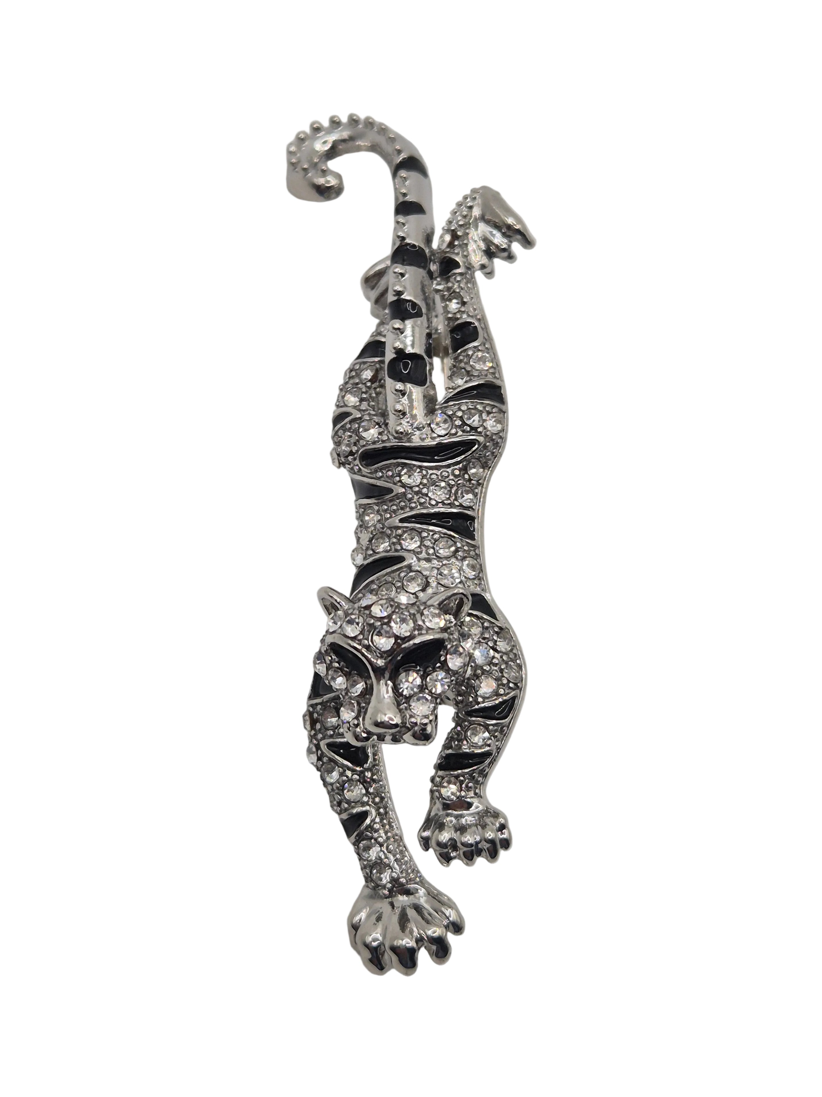 Silver tiger brooch with gemstones on a white background
